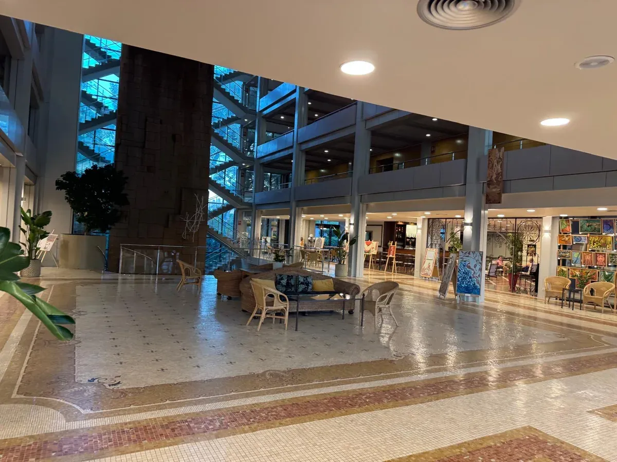 Vestíbulo del hotel con zonas de asiento y escaleras acristaladas